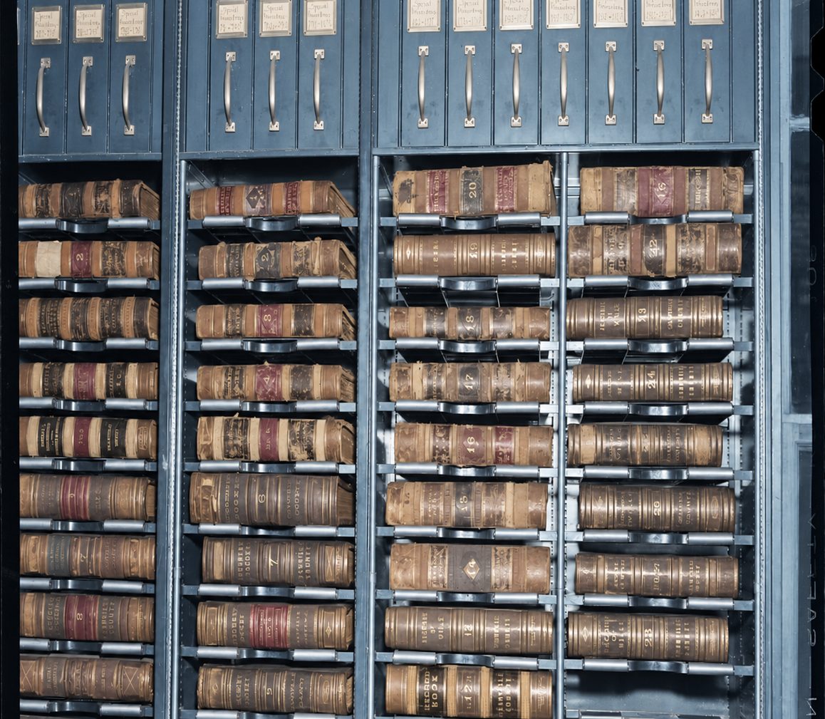 Bound county record books on steel shelving